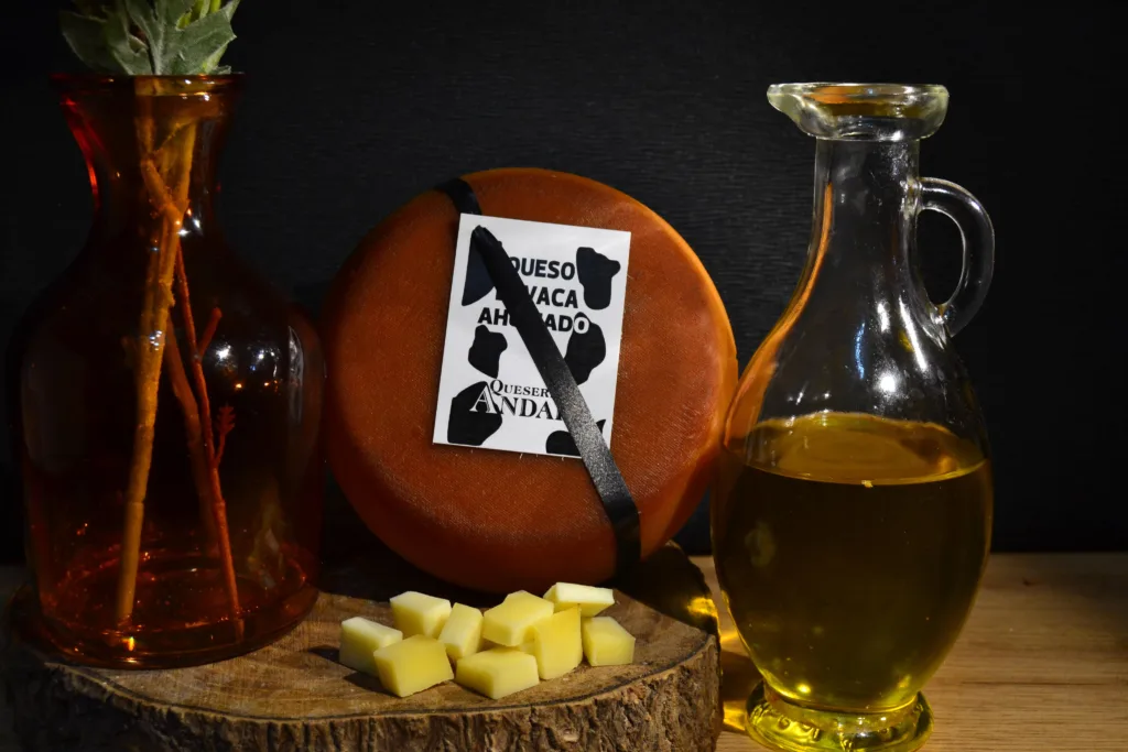 Queso de vaca ahumado sobre tocon acompañado de botella de aceite